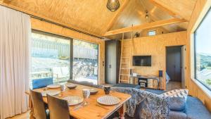 a dining room with a table and a couch at Picture Perfect - Queenstown Holiday Home in Queenstown