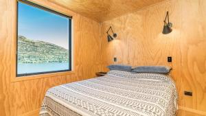 a bedroom with a bed and a large window at Picture Perfect - Queenstown Holiday Home in Queenstown