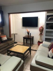 Il comprend un salon avec des canapés et une télévision à écran plat. dans l'établissement apartamento tony Chumpos, à San Felipe