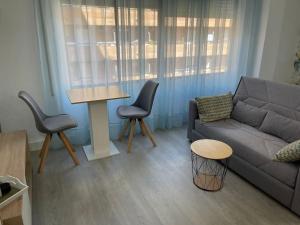 uma sala de estar com um sofá, cadeiras e uma mesa em Oasis Plus em Sevilha