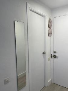 uma casa de banho com um espelho e uma porta branca em Oasis Plus em Sevilha