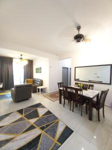 a living room with a table and chairs and a couch at SAFIYYA HOMES MERU RAYA - WIFI/NETFLIX in Ipoh