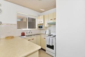 una cocina con fregadero y estufa horno superior en Waterviews on Marine Apartment 1, en The Entrance