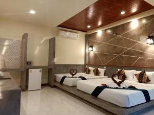 a hotel room with three beds in it at Lanta Pearl Beach Resort in Ko Lanta