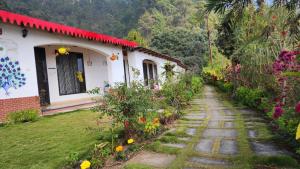 ein Haus mit einem Pfad vor einem Garten in der Unterkunft Just Naturals Wellness Resort Nainital in Bhowāli