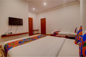 a bedroom with two beds and a flat screen tv at FabHotel Sri Udupi Park in Bengaluru