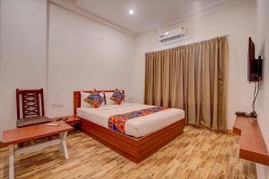 a bedroom with a bed and a desk and a television at FabHotel Sri Udupi Park in Bengaluru +23 photos