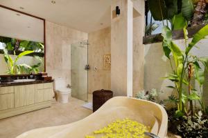 a bathroom with a tub and a shower and a sink at Villa Tenang by Nakula in Canggu