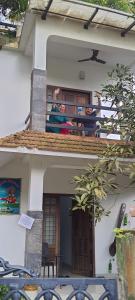 dos personas sentadas en el balcón de una casa en ABRU'S Holidays Foreign travelers, en Alleppey