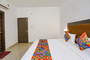 a bedroom with a large white bed with colorful pillows at Via The Prasiddh in Agra