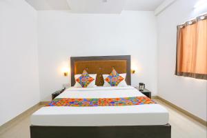 a bedroom with a large bed with colorful pillows at Via The Prasiddh in Agra