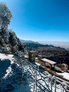 a bench sitting on top of a mountain in the snow at Jabal Dana Hotel - the highest hotel in Jordan in Dana
