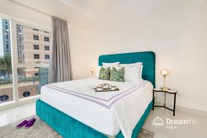 a bedroom with a large bed with a large window at Dream Inn Dubai - Damac Heights Marina in Dubai