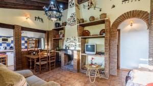 Los Almendros de Manuela El Borge by Ruralidays في Borge: غرفة معيشة مع موقد وغرفة طعام