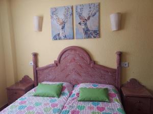a bedroom with a bed with two deer paintings on the wall at Casa Beatriz in Cala San Vicente