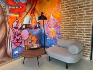 a chair and a lamp in a room with a painting at HOTEL 9.5 SAN FERNANDO in Cali