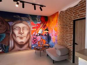 ein Wohnzimmer mit einem großen Gemälde an der Wand in der Unterkunft HOTEL 9.5 SAN FERNANDO in Cali