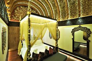 a bedroom with a canopy bed and a mirror at Sawasdee Village in Kata Beach