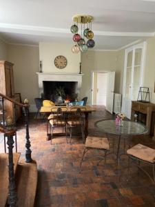 a living room with a table and a fireplace at Hôtel les Grands Chênes in Saint-Fargeau