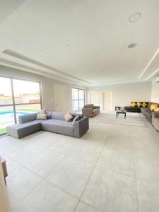 ein großes Wohnzimmer mit Sofas und einem Pool in der Unterkunft شاليه ريفان in Umm Lajj