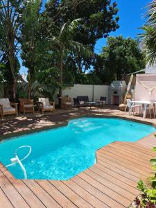 a swimming pool with a wooden deck next to a yard at THE BIG - Luxury Backpackers in Cape Town