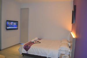 sypialnia z łóżkiem z telewizorem na ścianie w obiekcie Ashley Boutique Hotel w mieście Kota Damansara
