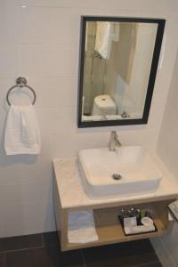 W łazience znajduje się umywalka i lustro. w obiekcie Ashley Boutique Hotel w mieście Kota Damansara