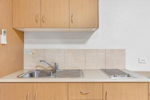 una cucina con lavello e mobili in legno di Midlander Motor Inn a Emerald
