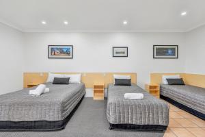 una camera d'albergo con due letti e quadri alle pareti di Midlander Motor Inn a Emerald