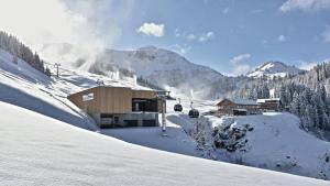 un lodge de ski dans la neige avec une remontée mécanique dans l'établissement Haus im WALDner, à Mellau