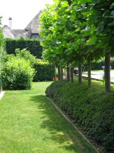 a garden with green grass and trees and a sidewalk at B&B Maaltebrug in Ghent