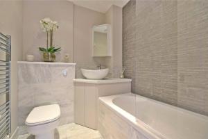 a bathroom with a tub and a toilet and a sink at Private 2 Bed Apartment / HUGE OUTDOOR TERRACE in London