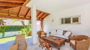 コニル・デ・ラ・フロンテーラにあるVilla con Encanto Conil de la Frontera by Ruralidaysのパティオ(籐家具、テーブル、椅子付)