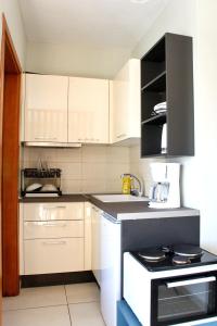 cocina con armarios blancos y estufa en blanco y negro en Sunny Street Studio, en Tesalónica