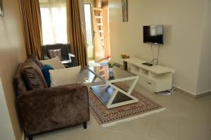 a living room with a couch and a tv at Haven Homely Apartments in Kampala +6 photos
