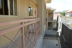 a balcony of a house with a wooden railing at Haven Homely Apartments in Kampala
