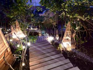 a wooden pathway with lights in a garden at night at Tsukie no Fune in Kobe