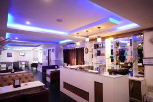 ein Restaurant mit einer Bar und eine Lobby mit lila Lichtern in der Unterkunft Hotel Gaurab Near Paltan Bazaar in Dehradun