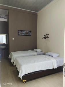 a group of four beds in a room at Bu Sepuh GuestHouse in Sangkanurip