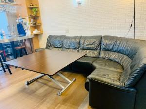 a leather couch with a table in a living room at YokohamaKannai HouseBar in Yokohama
