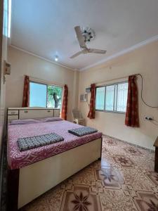 1 dormitorio con 1 cama y ventilador de techo en Sahil Residency, en Murud