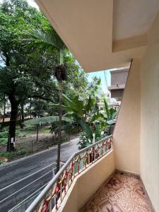 balcón con vistas a la calle y a los árboles en Sahil Residency, en Murud