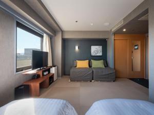 a bedroom with a bed and a flat screen tv at EN HOTEL Kyoto in Kyoto