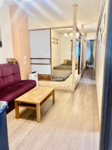 ein Wohnzimmer mit einem lila Sofa und einem Bett in der Unterkunft YokohamaKannai HouseBar in Yokohama