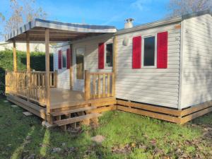Casa móvil con porche y persianas rojas en Camping les Mancellieres en Avrillé