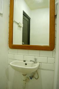łazienka z umywalką i lustrem na ścianie w obiekcie Tab Hotel Legian Bali w mieście Seminyak