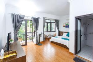 a bedroom with a bed and a balcony at Blue Eyes Hotel in Văn Lâm