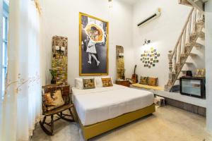 廊開的住宿－Silsopa Hostel，卧室配有一张床,墙上挂有绘画作品