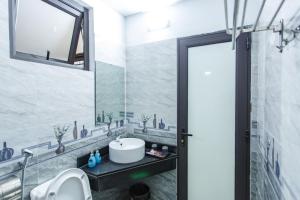 un baño con lavabo y espejo en Blue Eyes Hotel, en Văn Lâm