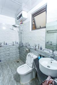 Un baño con un inodoro blanco y un lavabo. en Blue Eyes Hotel, en Văn Lâm